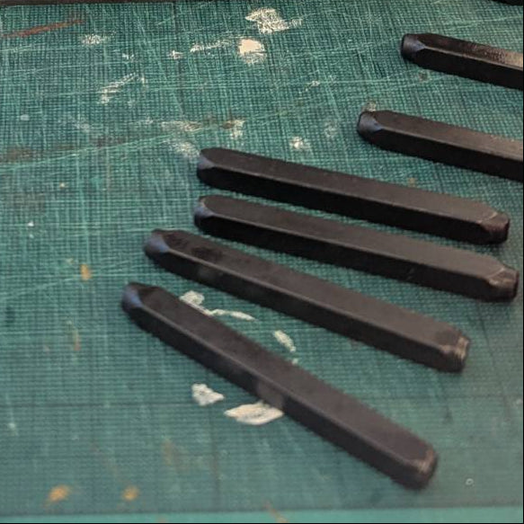 Person working on a small mechanical device with tools and components on a workbench.